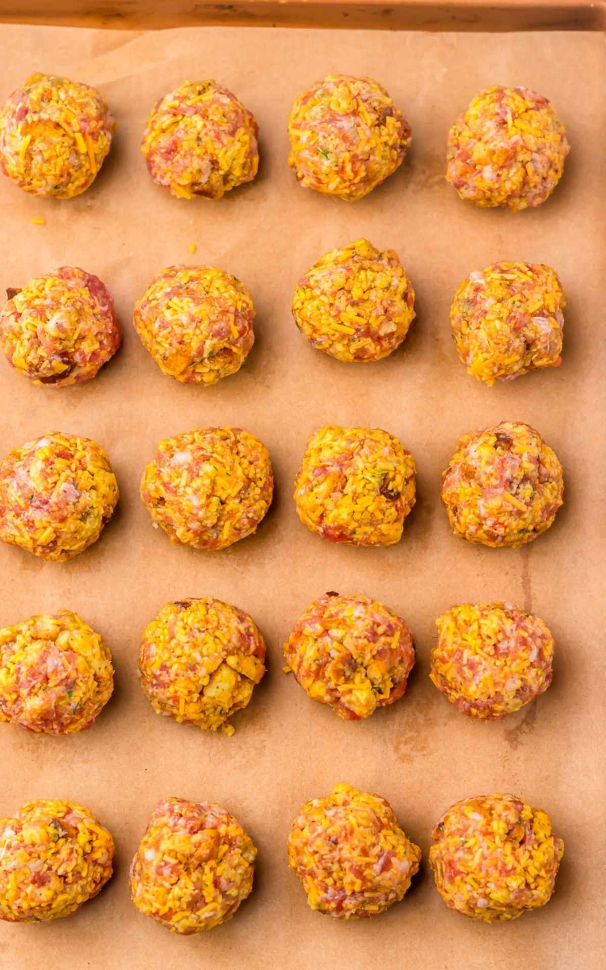 Sausage balls with stuffing on baking sheet.
